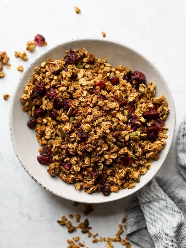 Overhead view of pumpkin spice granola in a white serving bowl.