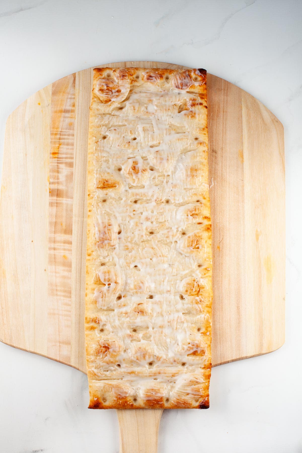 flatbread with ranch dressing on wood pizza peel 